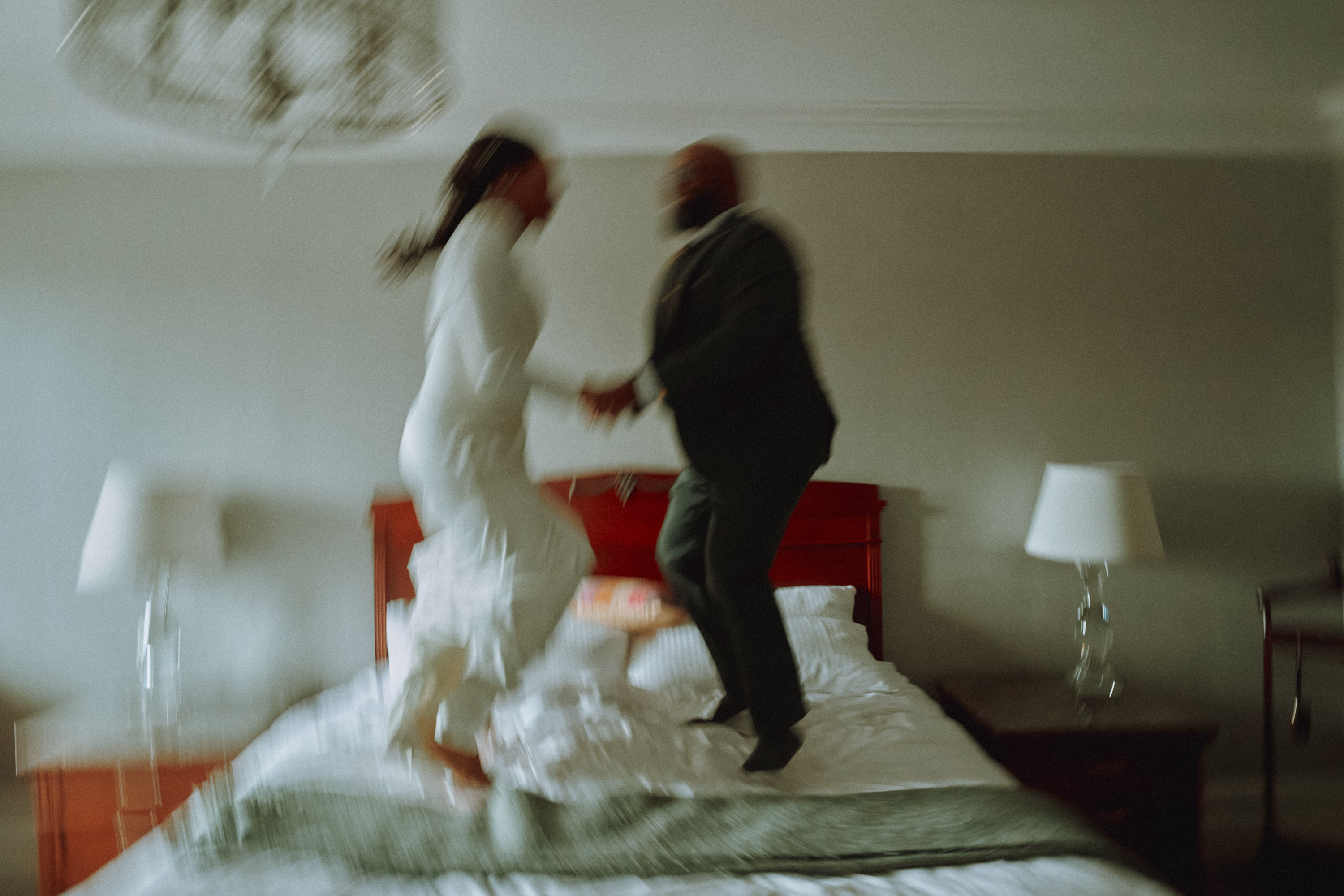 Authentic wedding morning moment of a couple celebrating on a bed
